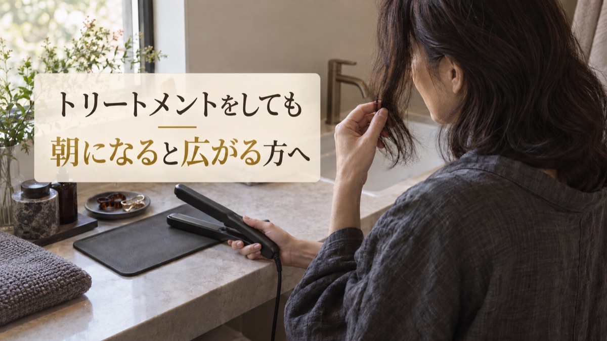 朝の洗面台で毛先を確認しながらヘアアイロンを持つ大人女性